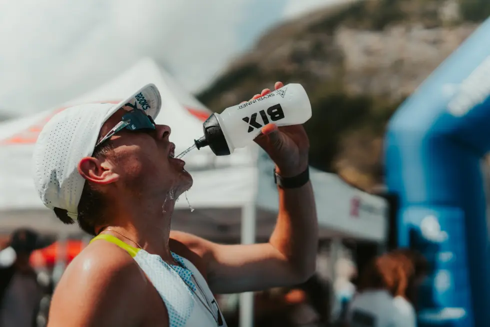 Athlete drinking water from skyrunner branded bottle