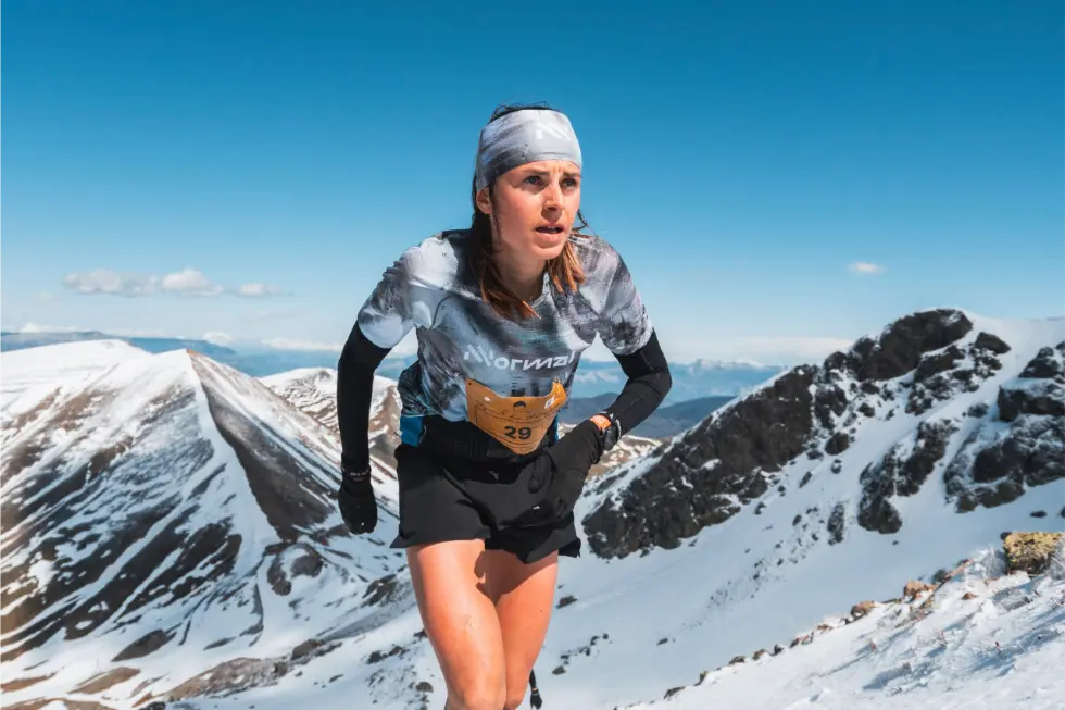 Female athlete climbing up a mountain in the snow for Skyrace des Matheysins