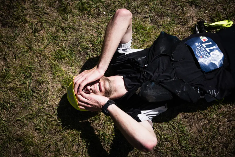 Male athlete on the floor with hands on face