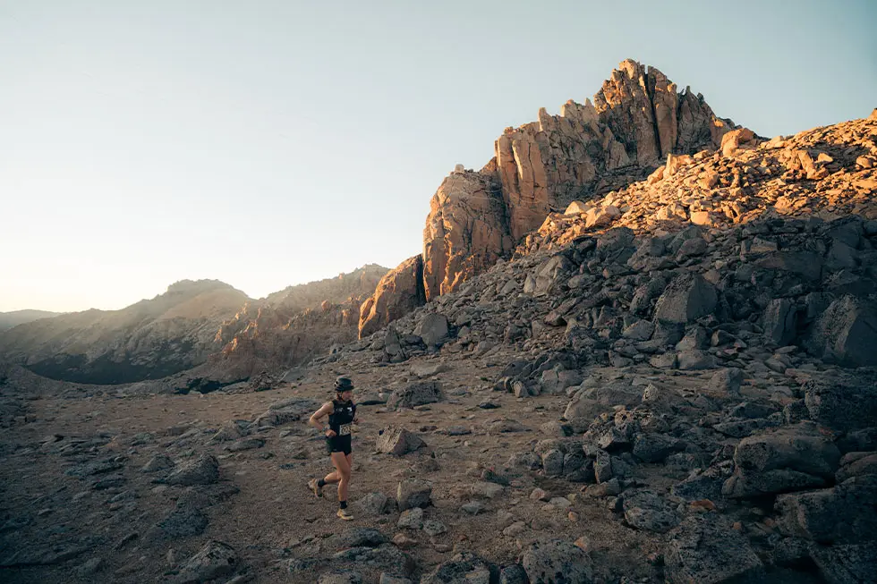 Mountain runner completing a steep uphill workout on a technical trail